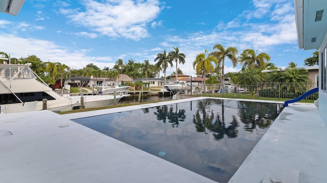 view of swimming pool with a water view and a boat dock