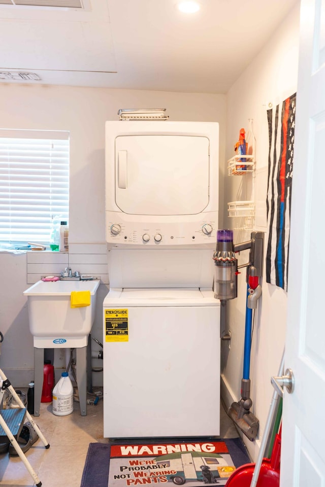 washroom featuring stacked washer / dryer and sink