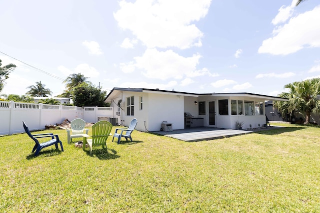 back of property featuring central AC unit, a lawn, a sunroom, and a deck