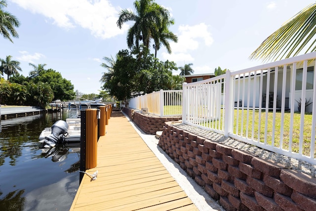 dock area with a water view and a yard