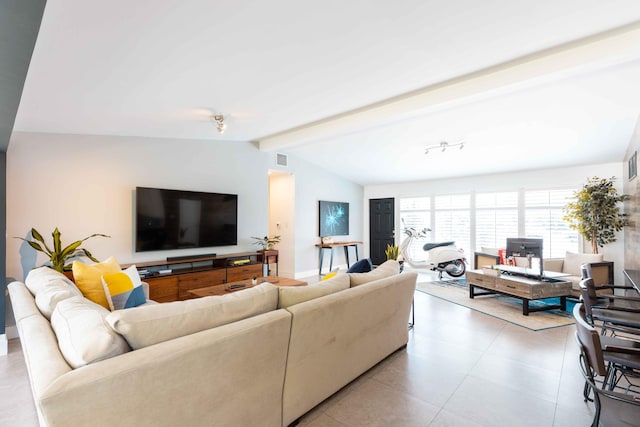 living room with lofted ceiling with beams and light tile patterned floors