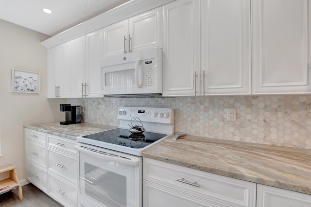 kitchen with white appliances, light stone countertops, white cabinetry, and decorative backsplash