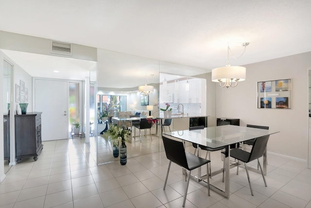 dining area with light tile patterned floors and a notable chandelier