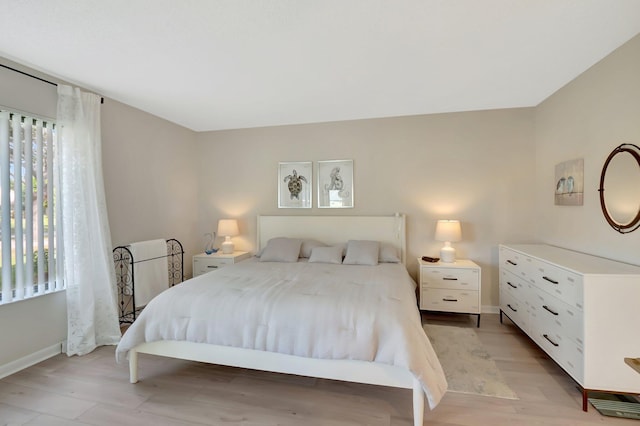 bedroom with light wood-style flooring and baseboards