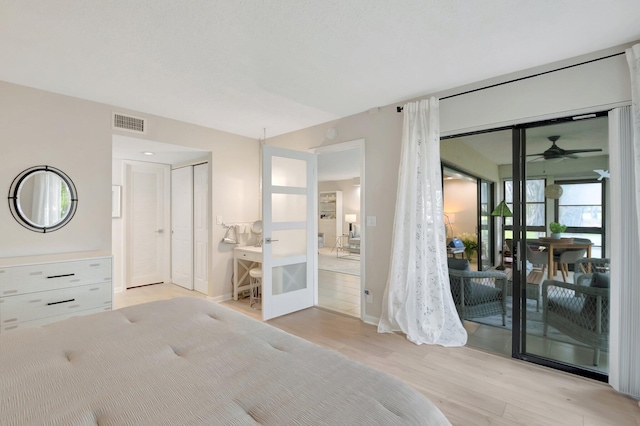 bedroom featuring access to outside, light wood-style flooring, visible vents, and baseboards