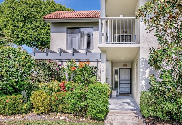 5659 Fairway Park Dr Unit 101, Boynton Beach, FL 33437 - entrance to property featuring stucco siding, a tiled roof, and a balcony