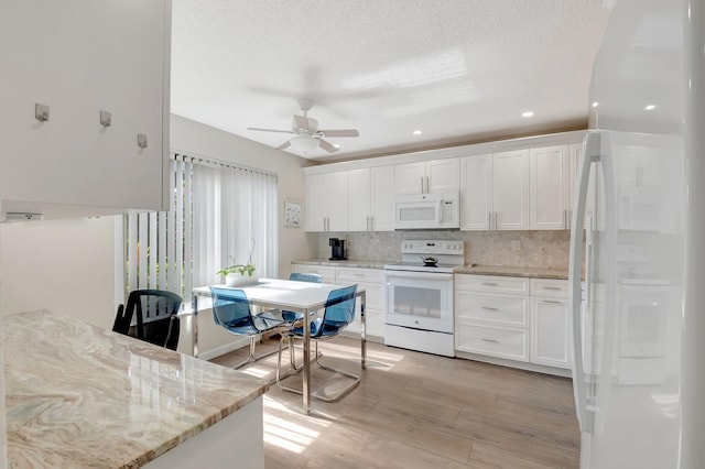 kitchen featuring white cabinetry, light stone counters, white appliances, light hardwood / wood-style floors, and decorative backsplash