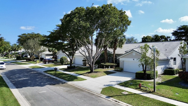 exterior space with cooling unit, a garage, and a front yard