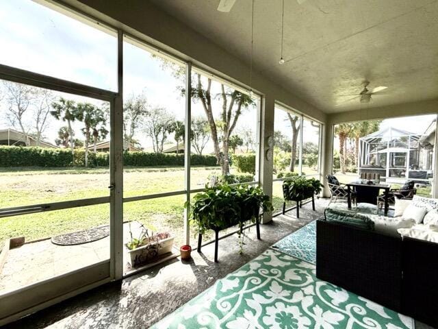 sunroom / solarium with a healthy amount of sunlight and ceiling fan