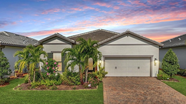 single story home with a garage and a lawn