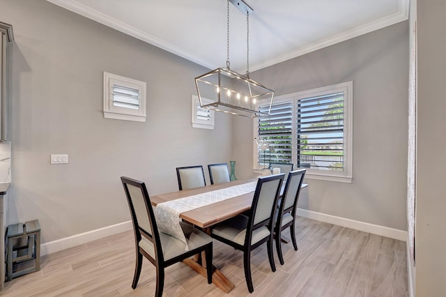 dining room with light hardwood / wood-style flooring, ornamental molding, and a chandelier