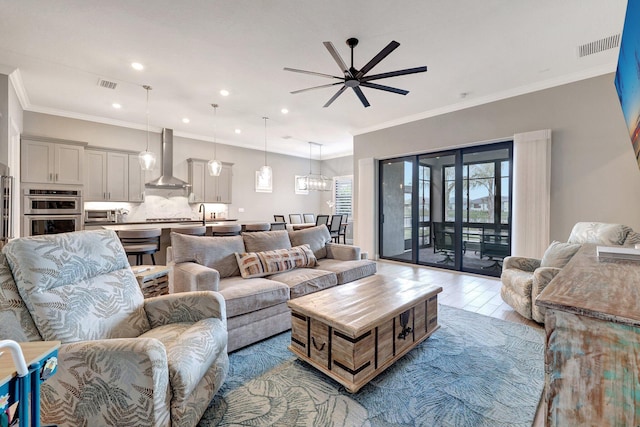 living room featuring ornamental molding, light hardwood / wood-style floors, and ceiling fan