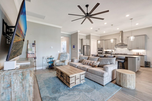 living room with sink, crown molding, and light wood-type flooring