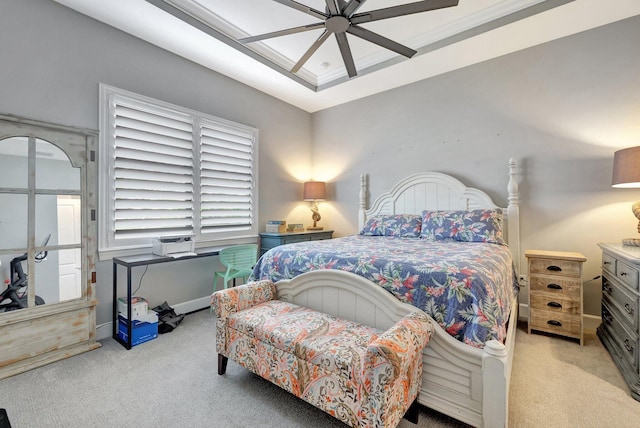 bedroom with a raised ceiling, light carpet, and ceiling fan