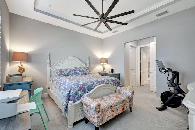 carpeted bedroom featuring ceiling fan, ornamental molding, and a tray ceiling