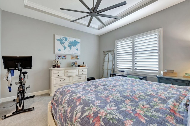 carpeted bedroom with ceiling fan, ornamental molding, and a raised ceiling