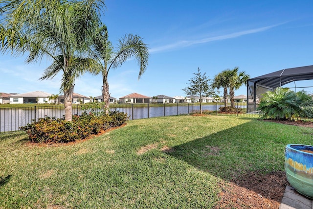 view of yard with a water view and glass enclosure