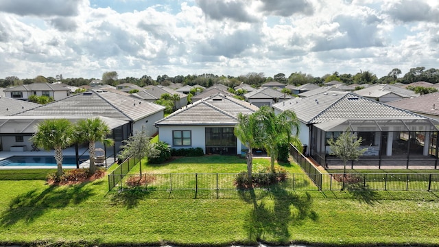 view of front of property with a fenced in pool, glass enclosure, and a front yard