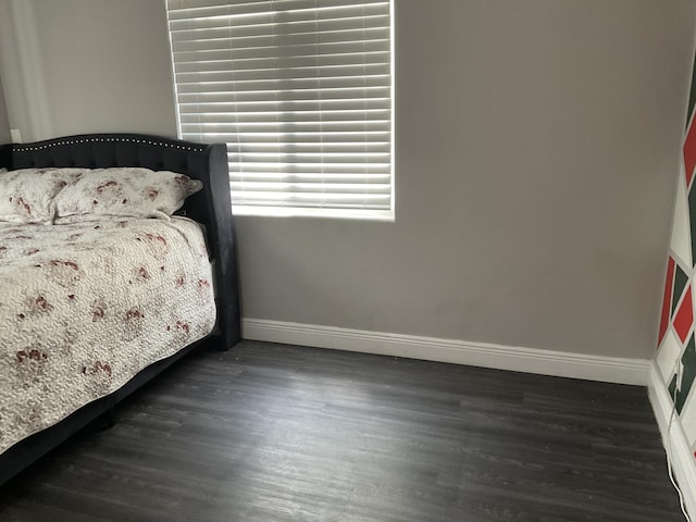 bedroom with dark hardwood / wood-style flooring