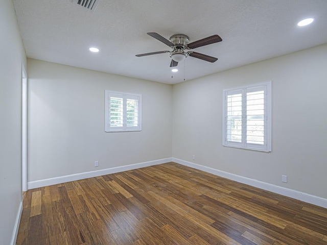 spare room featuring dark wood-type flooring, ceiling fan, and a textured ceiling