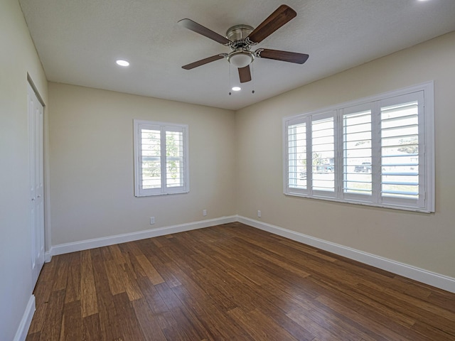 empty room featuring ceiling fan, a textured ceiling, and dark hardwood / wood-style flooring