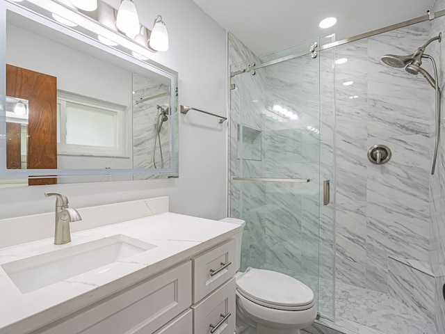 bathroom featuring vanity, toilet, and an enclosed shower