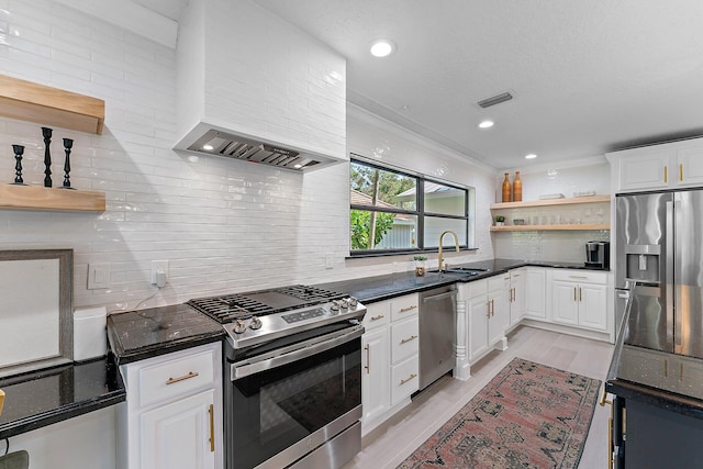 kitchen with sink, light hardwood / wood-style flooring, white cabinets, stainless steel appliances, and backsplash