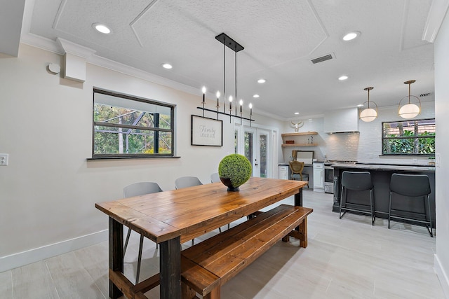 dining room with crown molding, french doors, and a textured ceiling