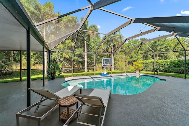 view of swimming pool featuring a patio area and glass enclosure