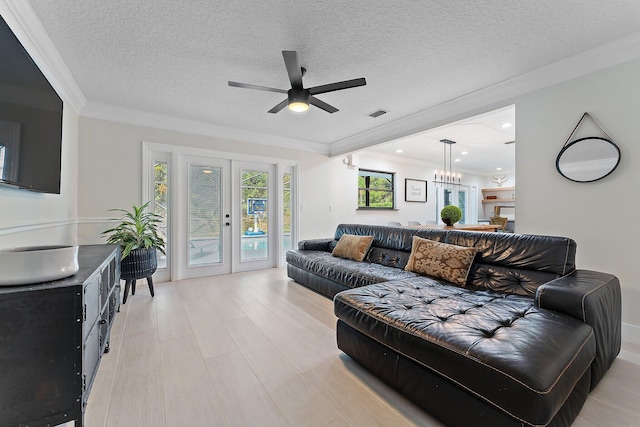 living room featuring crown molding, a textured ceiling, and french doors