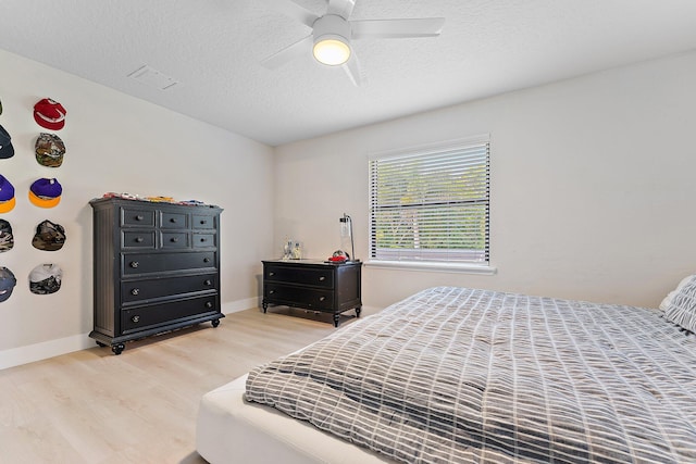 bedroom featuring hardwood / wood-style floors, a textured ceiling, and ceiling fan