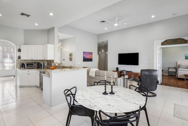 tiled dining space with ceiling fan