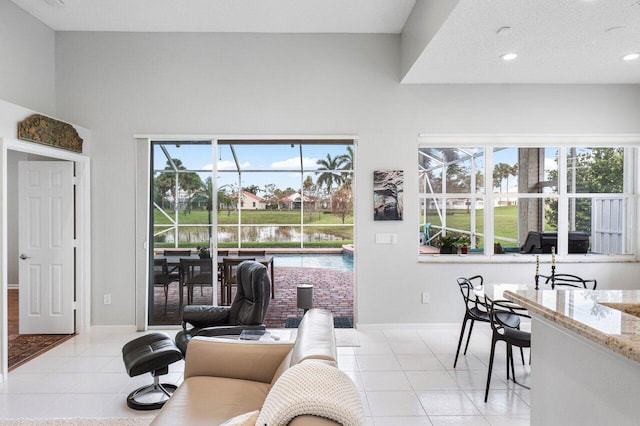 living room with light tile patterned floors and a water view