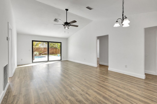 unfurnished living room with ceiling fan with notable chandelier, lofted ceiling, and hardwood / wood-style floors