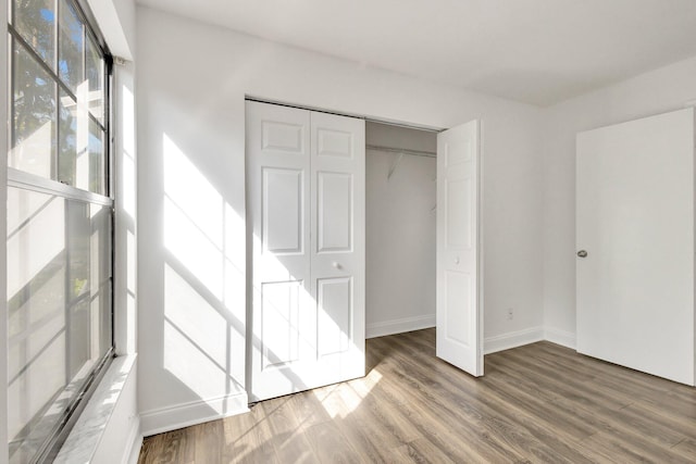 unfurnished bedroom featuring hardwood / wood-style flooring and a closet