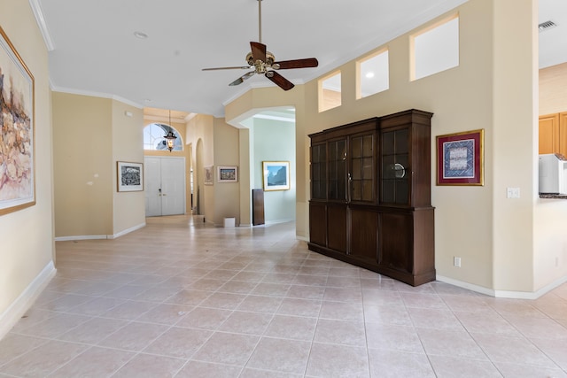 entrance foyer with light tile patterned floors, visible vents, arched walkways, ceiling fan, and ornamental molding