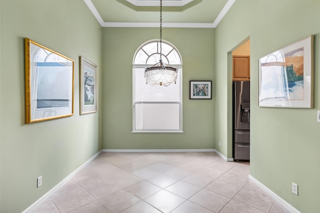 empty room featuring ornamental molding, a raised ceiling, light tile patterned flooring, and baseboards