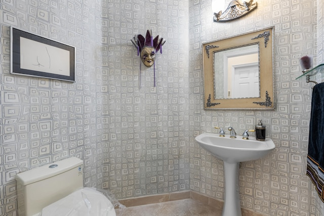 bathroom featuring toilet and wallpapered walls