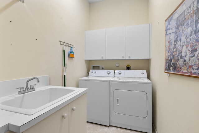 laundry area with cabinet space, a sink, and washing machine and clothes dryer