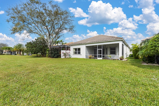 rear view of house featuring a sunroom and a yard