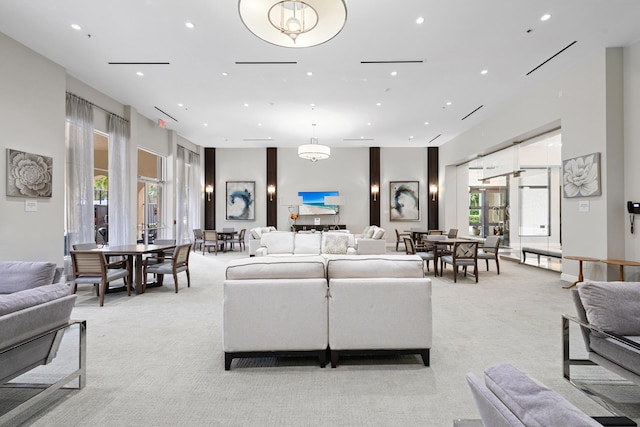 living area with recessed lighting and light carpet