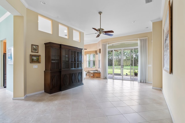 interior space with light tile patterned flooring, crown molding, and baseboards