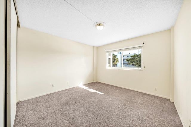 spare room with a textured ceiling and carpet flooring