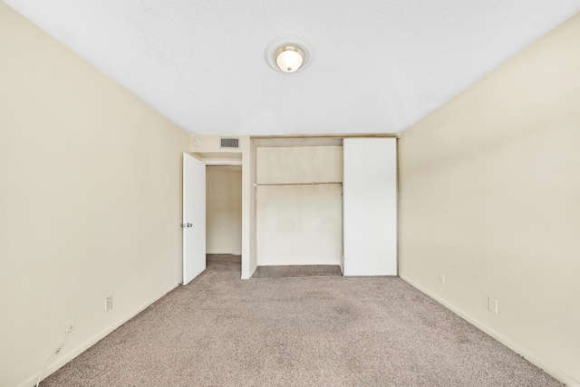 unfurnished bedroom featuring carpet flooring and a closet