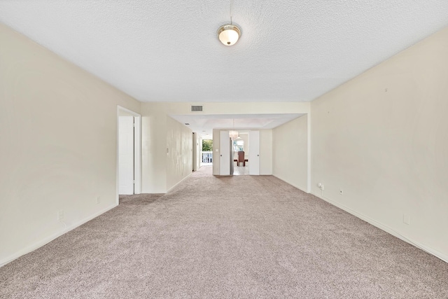 carpeted empty room featuring a textured ceiling