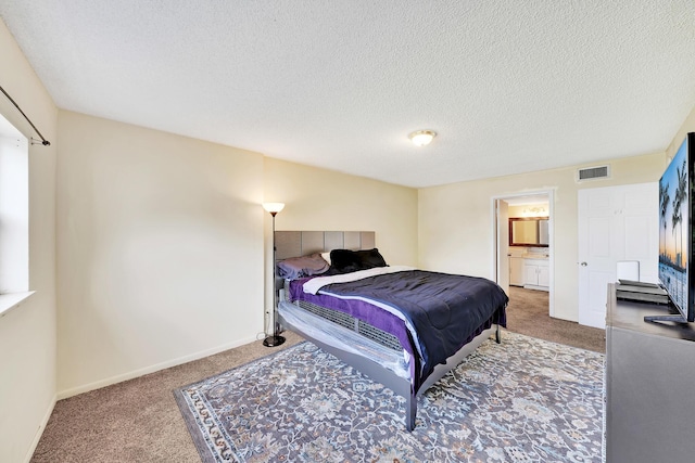 bedroom with connected bathroom, carpet flooring, and a textured ceiling