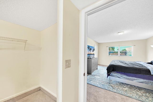 bedroom with a textured ceiling and carpet flooring