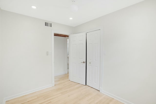 unfurnished bedroom featuring a closet and light hardwood / wood-style flooring