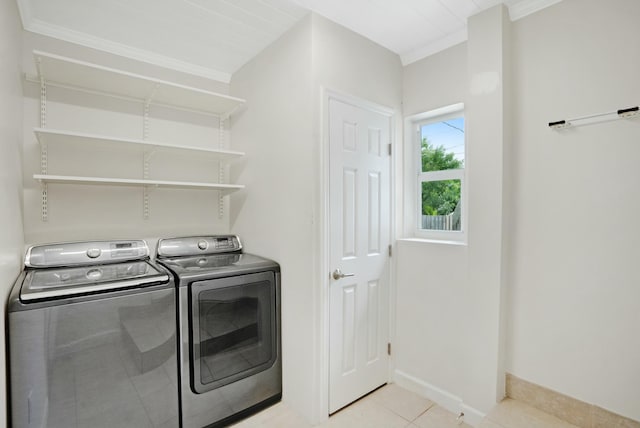 laundry area with crown molding, separate washer and dryer, and light tile patterned floors