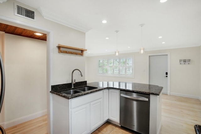 kitchen with decorative light fixtures, sink, dark stone countertops, white cabinets, and stainless steel dishwasher